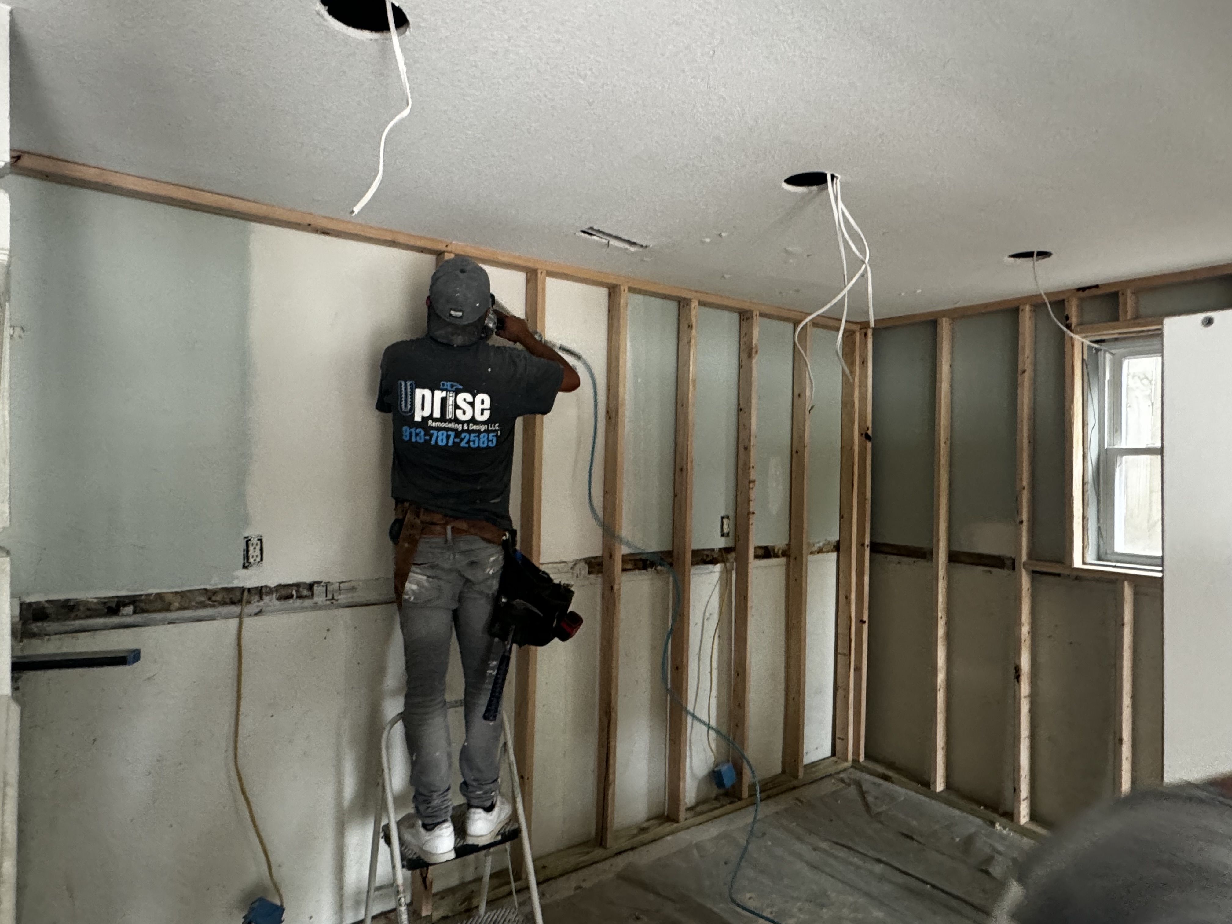 Uprise team member doing framing and electrical work
